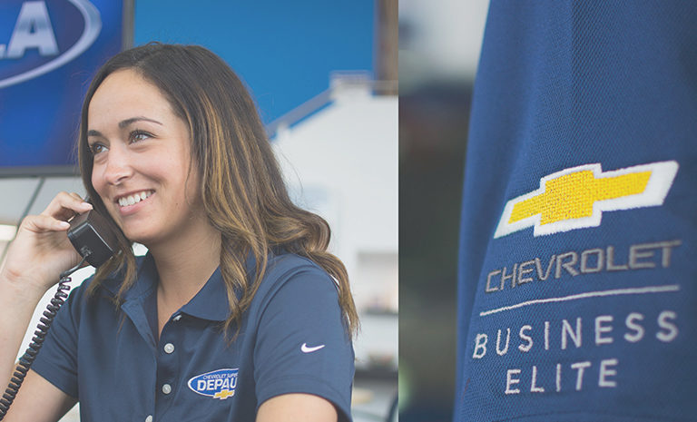 female employee at Depaula Chevrolet wearing a branded navy blue polo shirt