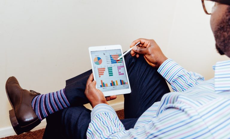 man looking at a series of pie charts, graphs, and tables of data