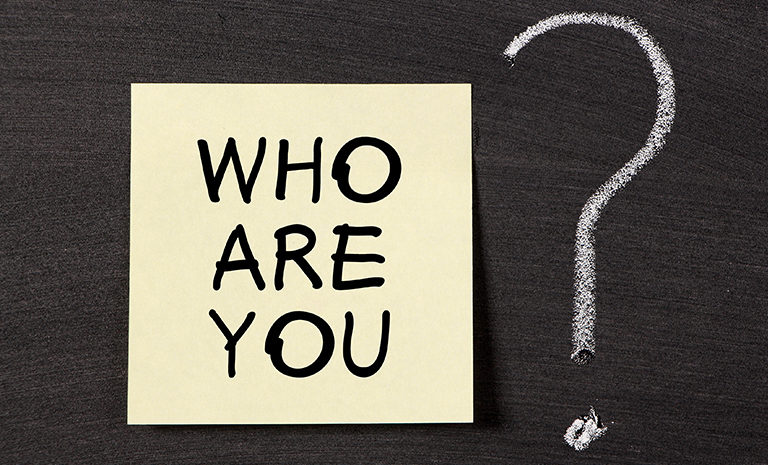 post-it that asks brands, "who are you?" with a question mark written in chalk to the right of the paper