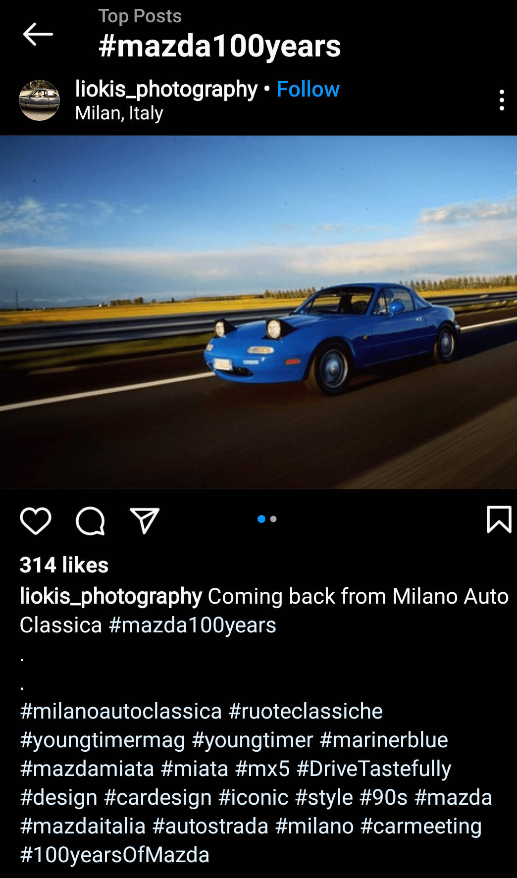 Instagram post showing a blue Mazda Miata MX-5 driving on a highway with a field in the background