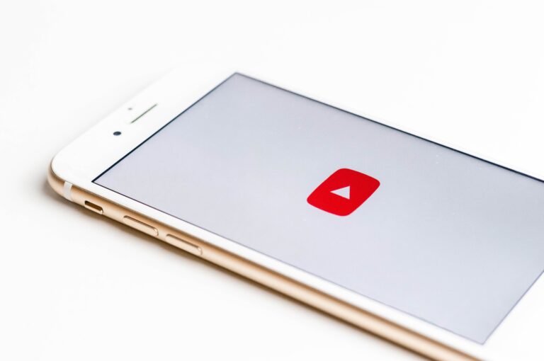white iPhone with the YouTube logo on the screen