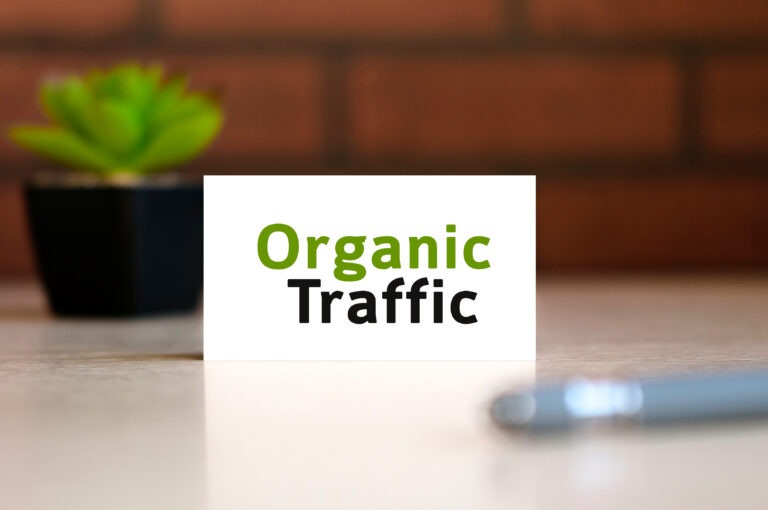 white note card that says organic traffic in bold letters next to a blue pen on a table