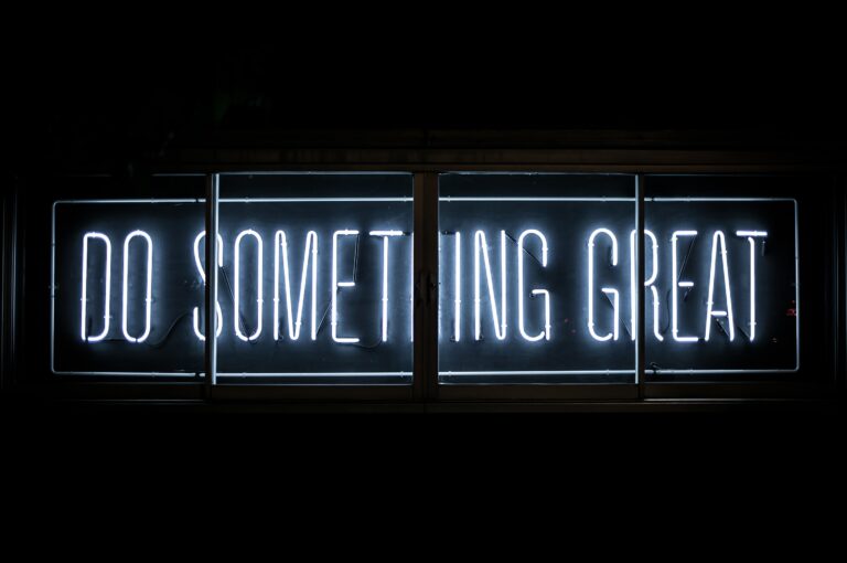 white neon sign that says do something great on a black background