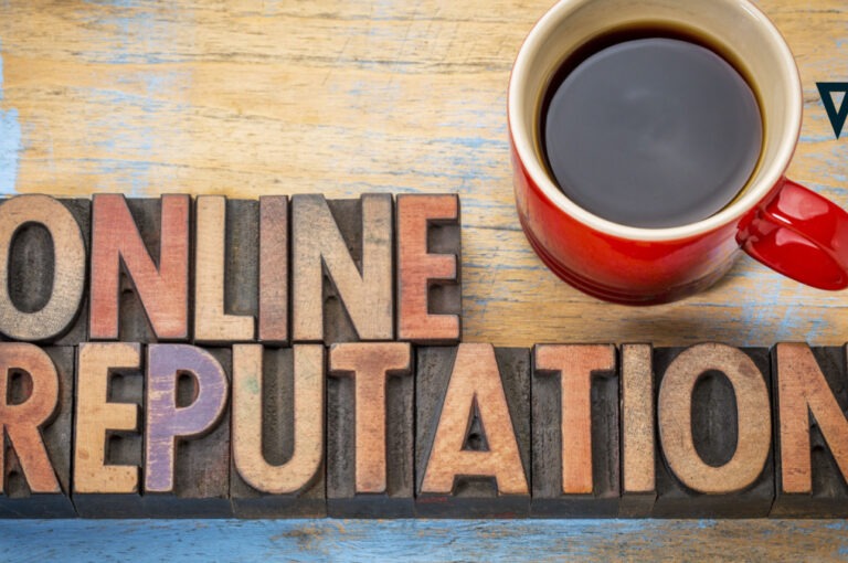 wooden blocks spelling online reputation next to a red mug with black coffee