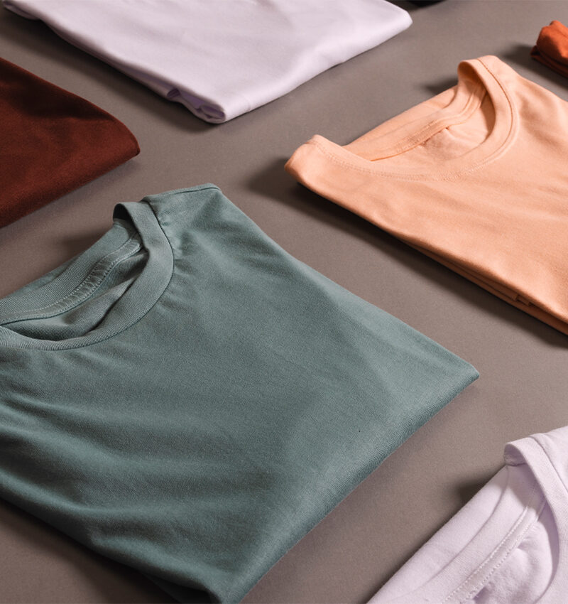colored shirts displayed on a grey surface